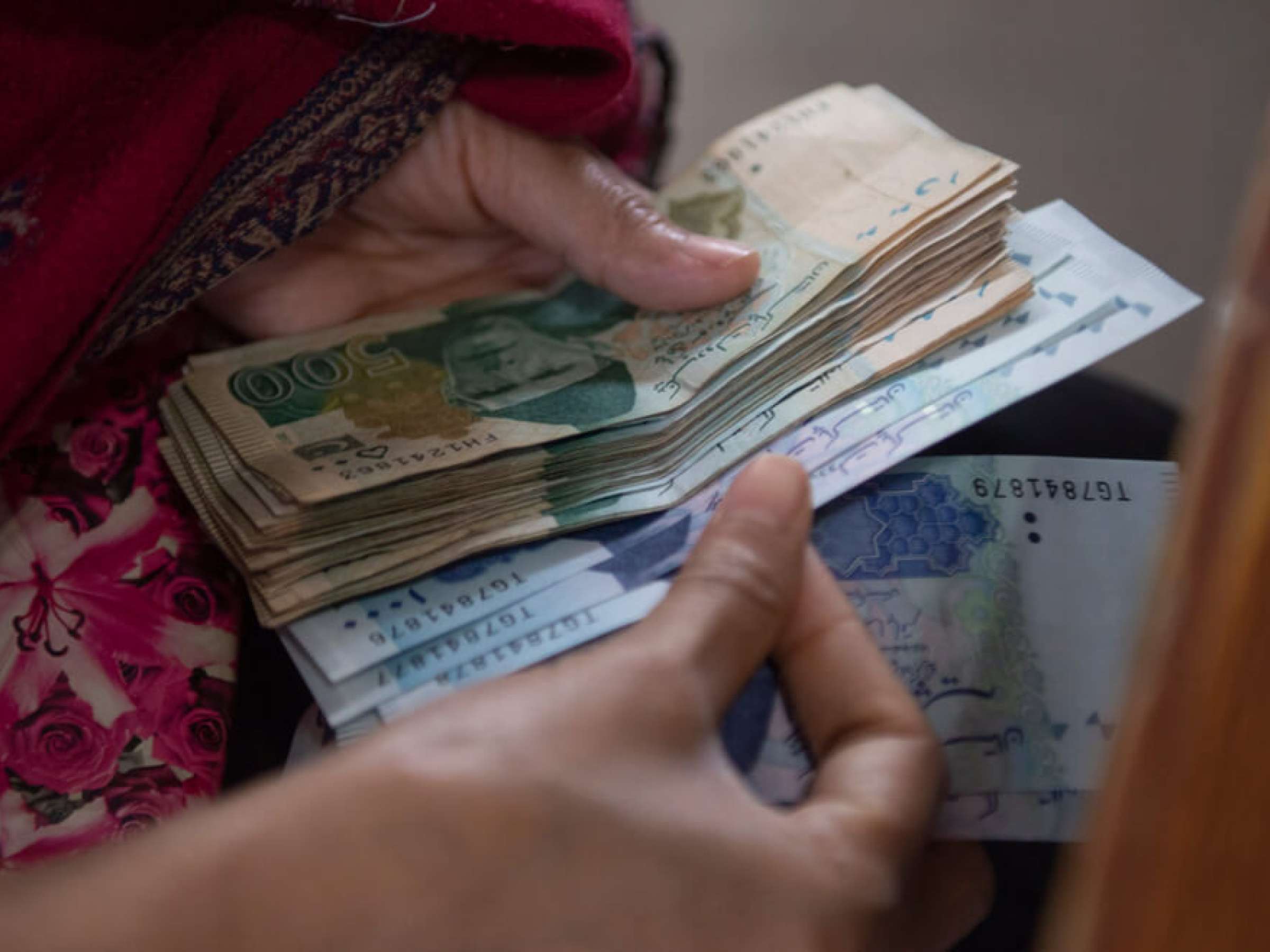 Women wait to receive cash of the governmental 'Ehsaas Emergency Cash Programme'